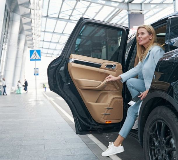 Gut gekleidete Frau steigt aus Flughafentaxi