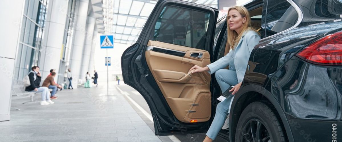 Gut gekleidete Frau steigt aus Flughafentaxi